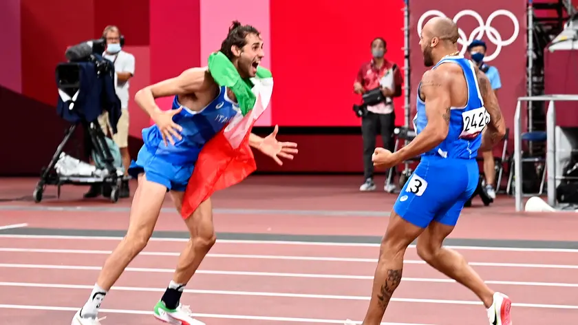 epa09385599 Gold Medalists in Men'sHigh Jump Gianmarco Tamberi of Italy (L) and gold medalist in Men's 100m Marcell Lamont Jacobs of Italy (R) celebrate during the Athletics events of the Tokyo 2020 Olympic Games at the Olympic Stadium in Tokyo, Japan, 01 August 2021. EPA/CHRISTIAN BRUNA