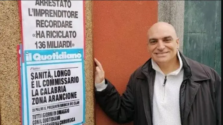Roberto Recordare mentre sghignazza davanti alle locandine dei giornali che annunciano l'inchiesta di mafia su di lui