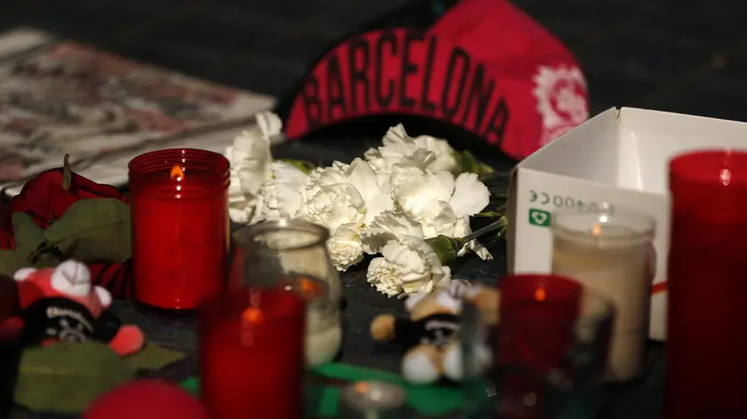 Candles and bunches of flowers placed by people rest on the ground in Las Ramblas, Barcelona, Spain, Friday, Aug. 18, 2017. Police on Friday shot and killed five people carrying bomb belts who were connected to the Barcelona van attack, as the manhunt intensified for the perpetrators of Europe's latest rampage claimed by the Islamic State group. (ANSA/AP Photo/Francisco Seco) [CopyrightNotice: Copyright 2017 The Associated Press. All rights reserved.]