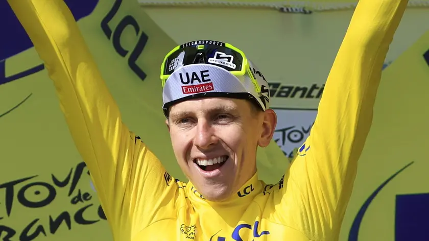 epa11477843 Slovenian rider Tadej Pogacar of UAE Team Emirates celebrates in the overall leader's yellow jersey on the podium after winning the 15th stage of the 2024 Tour de France cycling race over 197km from Loudenvielle to Plateau de Beille, France, 14 July 2024. EPA/GUILLAUME HORCAJUELO