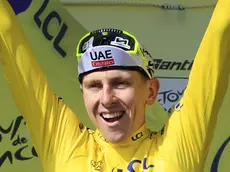 epa11477843 Slovenian rider Tadej Pogacar of UAE Team Emirates celebrates in the overall leader's yellow jersey on the podium after winning the 15th stage of the 2024 Tour de France cycling race over 197km from Loudenvielle to Plateau de Beille, France, 14 July 2024. EPA/GUILLAUME HORCAJUELO