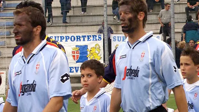 L'ingresso in campo dei giocatori del Treviso (terzo da sinistra il nigeriano Omolade) con il volto dipinto di nero, prima dell'inizio della partita contro il Genoa del 03 giugno 2001. L'inedita iniziativa era stata decisa per solidarietà verso Omolade e per protesta contro quei tifosi trevigiani che a Terni abbandonarono lo stadio all'ingresso in campo del giocatore nigeriano. Nella gara contro il Genoa, terminata con un pareggio, Omolade segno' un goal nel secondo tempo. ANSA/STRINGER