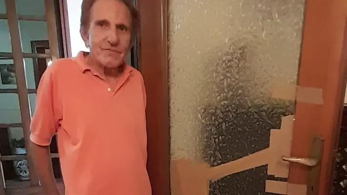 Danilo Zoccarato davanti al vetro di una porta andato in pezzi