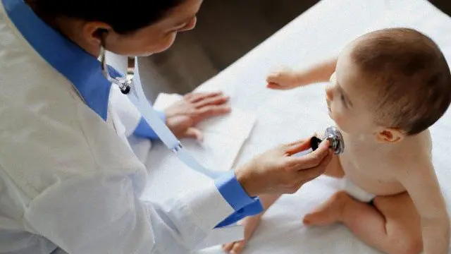 Un pediatra mentre visita un bambino