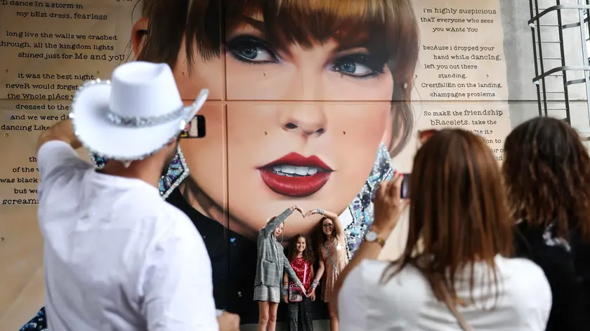 epa11550231 Taylor Swift fans pose for photographs in front of a mural outside Wembley Stadium before the first of the current Eras Tour series of concerts at Wembley Stadium, in London, Britain, 15 August 2024. The last concerts of US pop star's Eras Tour in Europe take place at London's Wembley Stadium from 15 to 20 August 2024. The concerts will go ahead amid additional security measures following the cancellation of Swift's three shows in Vienna earlier in August 2024. London Metropolitan Police's spokesperson had said that 'There is nothing to indicate that the matters being investigated by the Austrian authorities will have an impact on upcoming events here in London.' EPA/ANDY RAIN