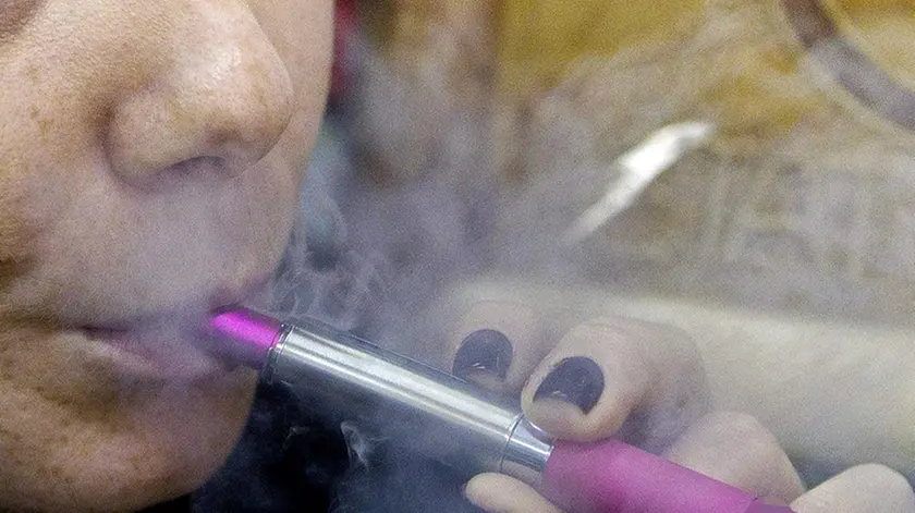Una ragazza fuma una sigaretta elettronica in un locale pubblico a Roma. 27 dicembre 2012. ANSA/CLAUDIO PERI