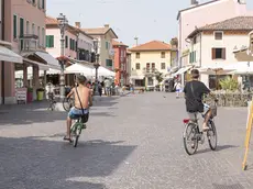 Un ciclista a torso nudo in centro a Caorle (Foto Vianello)