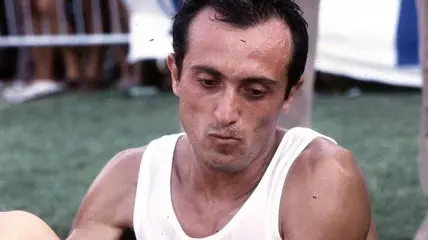 Pietro Mennea si sistema una scarpa seduto per terra in una foto senza data. ANSA