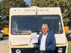Stefano Galian davanti al suo camper, mostra la multa