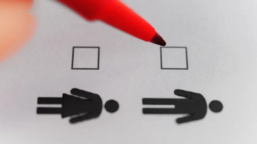 Person marking with pen on male and female gender checklistÂ