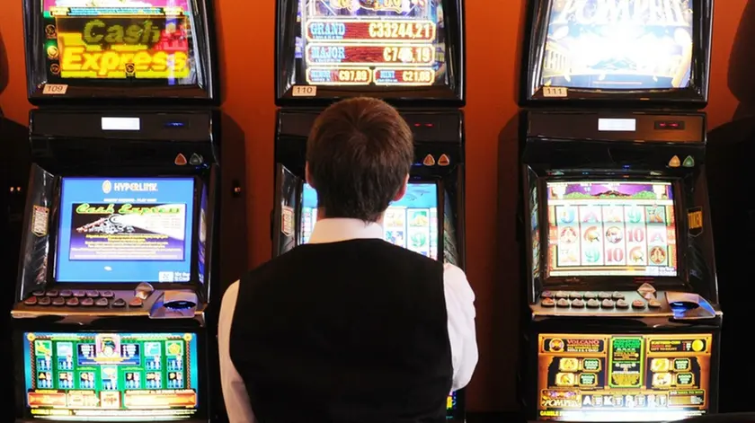 14 Jun 2012, Westerland, Sylt, Germany --- Illustration - A man sits on a slot machine at the casino in Westerland on the island of Sylt, Germany, 14 June 2012. The casino offers events such as the 'Bikers' Night' nad the 'Kitesurf Poker Trophy'. Photo: Angelika Warmuth --- Image by © Angelika Warmuth/dpa/Corbis
