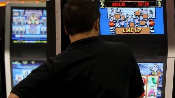 Un uomo gioca con una slot machine in una foto d'archivio. ANSA / YM YIK .