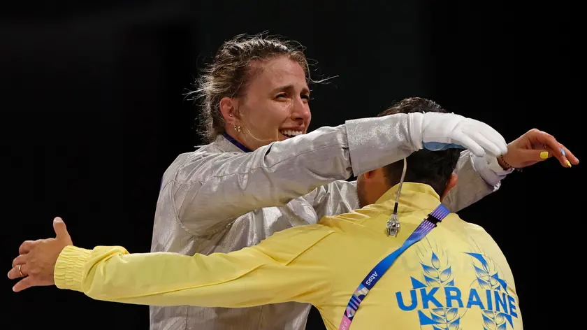 epa11507225 Olga Kharlan of Ukraine celebrates with her coach after beating Sebin Choi of Korea during Women Sabre Individual Bronze madal bout in the Fencing competitions in the Paris 2024 Olympic Games, at the Grand Palais in Paris, France, 29 July 2024. EPA/YOAN VALAT