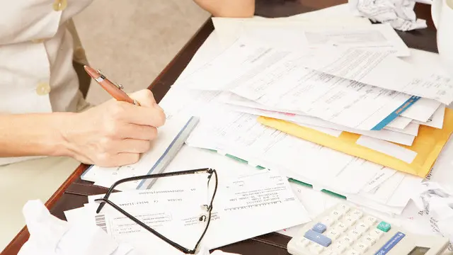 Frustrated Woman Paying Bills and Working on Home Finances --- Image by © Jack Hollingsworth/Corbis