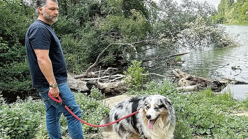 Gian Paolo Falferi e il cane Dylan nel punto dove è stata soccorsa la donna finita in acqua