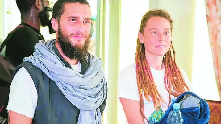 TOPSHOT - Italian Luca Tacchetto (L) and Canadian Edith Blais (R) are greeted by officials as they arrive at the airport in Bamako on March 14, 2020, after their release by UN peacekeepers. - A Canadian woman and her Italian partner kidnapped in Burkina Faso in 2018 have been found alive in the northwest of Mali by UN peacekeepers, diplomatic and UN sources said on March 14. "UN blue helmets found an Italian citizen and a Canadian citizen near Kidal, who had been taken hostage in Burkina territory in 2018," a security official from the UN mission in Mali, MINUSMA, told AFP. (Photo by MICHELE CATTANI / AFP)