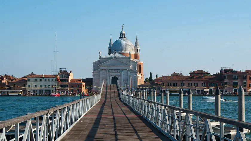 19 Jul 2014 --- VENICE, ITALY - JULY 19: A general view of the temporary pontoon bridge for the Redentore Celebrations is seen few minutes before the official opening on July 19, 2014 in Venice, Italy. Redentore , which is in remembrance of the end of the 1577 plague, is one of Venice's most loved celebrations. Highlights of the celebration include the pontoon bridge extending across the Giudecca Canal, gatherings on boats in the St. Mark's Basin and a spectacular fireworks display --- Image by © Luca Zanon/XianPix/Corbis