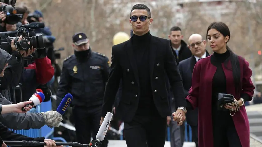 Cristiano Ronaldo arrives at the court in Madrid on Tuesday, Jan. 22, 2019. Cristiano Ronaldo is expected to plead guilty to tax fraud. The Juventus forward arrived in a black van, walked up some stairs leading to the court house and stopped to sign an autograph. The charges stem from his days at Real Madrid. (ANSA/AP Photo/Manu Fernandez) [CopyrightNotice: Copyright 2019 The Associated Press. All rights reserved.]