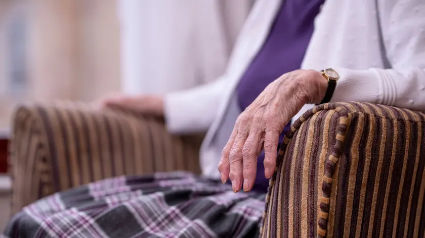 MODEL RELEASED. Care home resident. Hand of a seated 84-year-old woman in a care home. Photographed in Scarborough, UK.