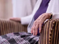 MODEL RELEASED. Care home resident. Hand of a seated 84-year-old woman in a care home. Photographed in Scarborough, UK.