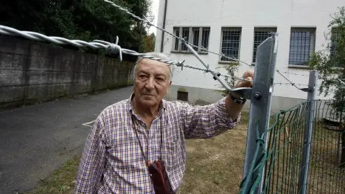 Un parrocchiano accanto al filo spinato