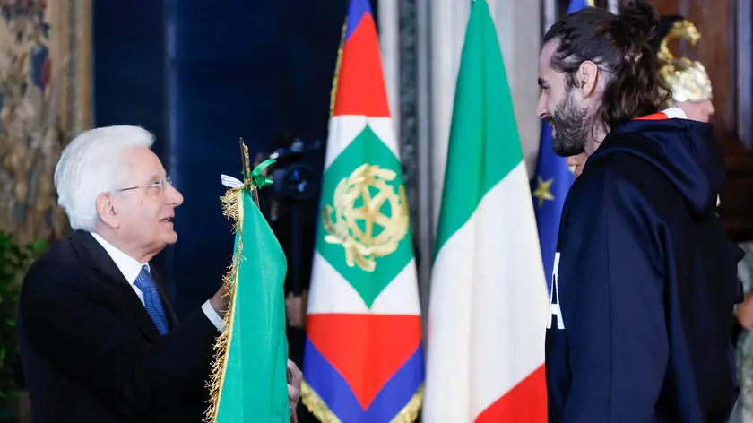 Il Presidente della Repubblica Sergio Mattarella (S) e Gianmarco Tamberi durante la cerimonia di restituzione della Bandiera degli atleti italiani di ritorno dai Giochi Olimpici e Paralimpici di Parigi 2024, Quirinale, Roma 23 settembre 2024. ANSA/FABIO FRUSTACI