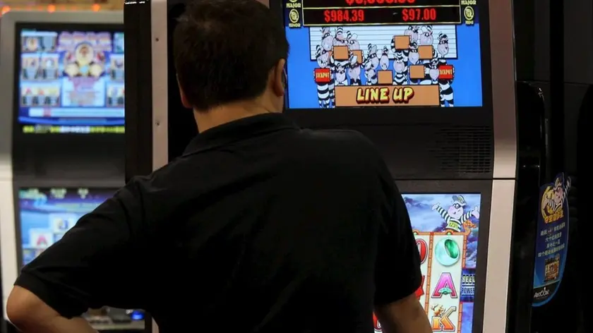 Un uomo gioca con una slot machine in una foto d'archivio. ANSA / YM YIK .