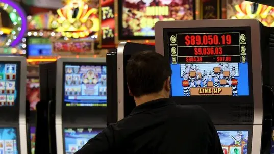 Un uomo gioca con una slot machine in una foto d'archivio. ANSA / YM YIK .