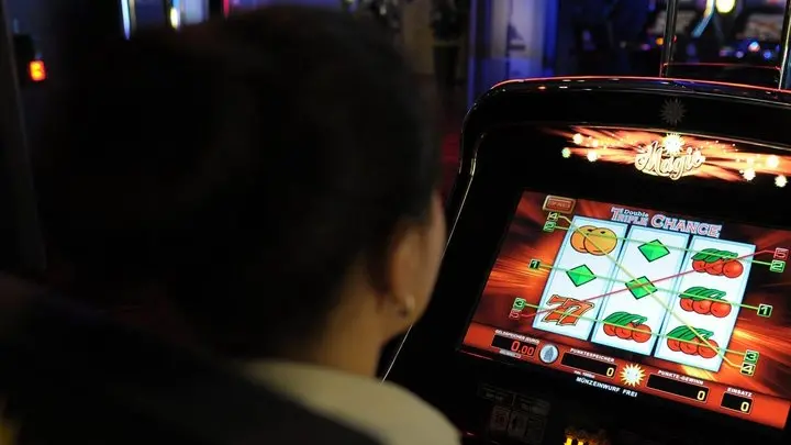 Una donna gioca con una slot machine in una foto d'archivio. ANSA / FEDERICO GAMBARINI