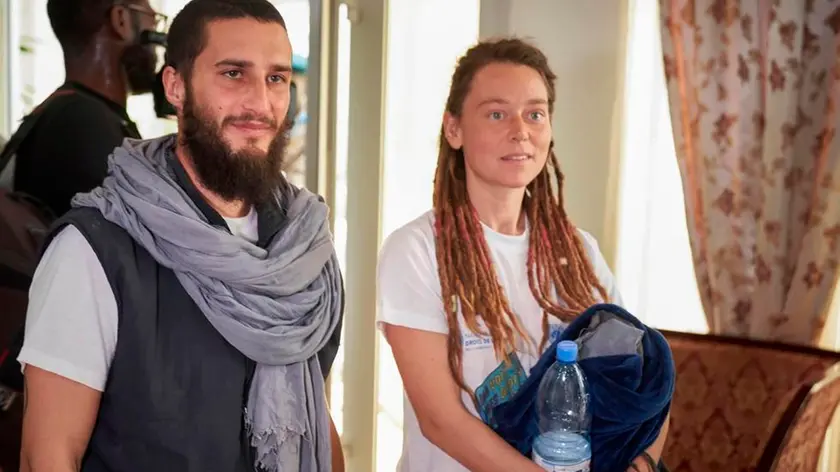 Italian Luca Tacchetto (L) and Canadian Edith Blais (R) are greeted by officials as they arrive at the airport in Bamako on March 14, 2020, after their release by UN peacekeepers. - A Canadian woman and her Italian partner kidnapped in Burkina Faso in 2018 have been found alive in the northwest of Mali by UN peacekeepers, diplomatic and UN sources said on March 14. "UN blue helmets found an Italian citizen and a Canadian citizen near Kidal, who had been taken hostage in Burkina territory in 2018," a security official from the UN mission in Mali, MINUSMA, told AFP. (Photo by MICHELE CATTANI / AFP)