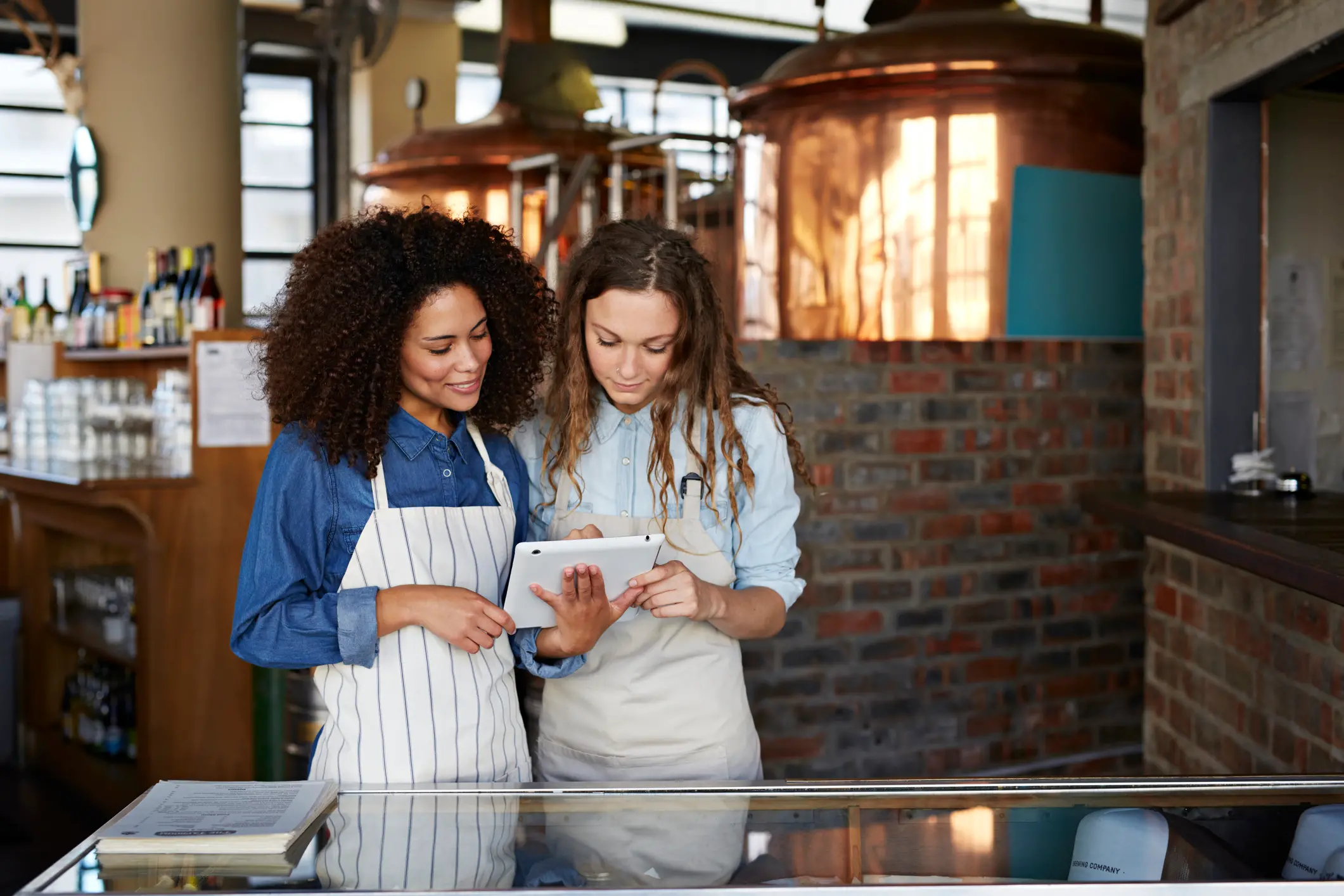 Two waiters looking at booking on tablet