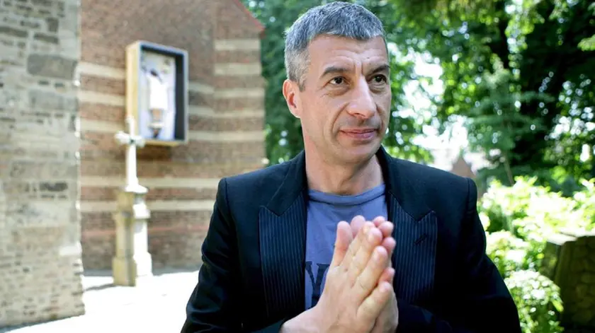 epa01364829 Controversial Italian artist Maurizio Cattelan stands in front of a crucified woman (back) at a wall of the Catholic Alt Sankt Martin church in Stommeln, Germany, 01 June 2008. Cattelan presented the crucification under the 'Project Synagogue Stommeln' that can be visited until 10 August. ANSA EPA/ROLF VENNENBERND DC*************** TRADUZIONE ***************epa01364829 artista italiano Maurizio Cattelan Controverso sta in piedi di fronte ad una donna crucifissa (indietro) ad un muro dell'Alt cattolico chiesa di Martin di Sankt in Stommeln, la Germania, 01 giugno 2008. Cattelan presentò il crucification sotto il' Progetto Sinagoga Stommeln quello può essere visitato fino a 10 agosto. ANSA EPA/ROLF VENNENBERND DC