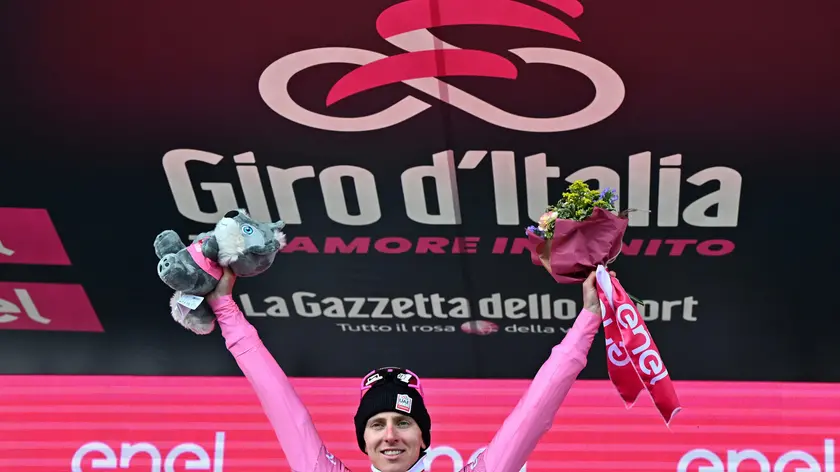 epa11353952 Slovenian rider Tadej Pogacar of Uae Team Emirates retaining the overall leader's pink jersey celebrates on the podium after winning the 15th stage of the 107th Giro d'Italia 2024 cycling tour, over 222 km from Manerba del Garda to Livigno, Italy, 19 May 2024. EPA/LUCA ZENNARO