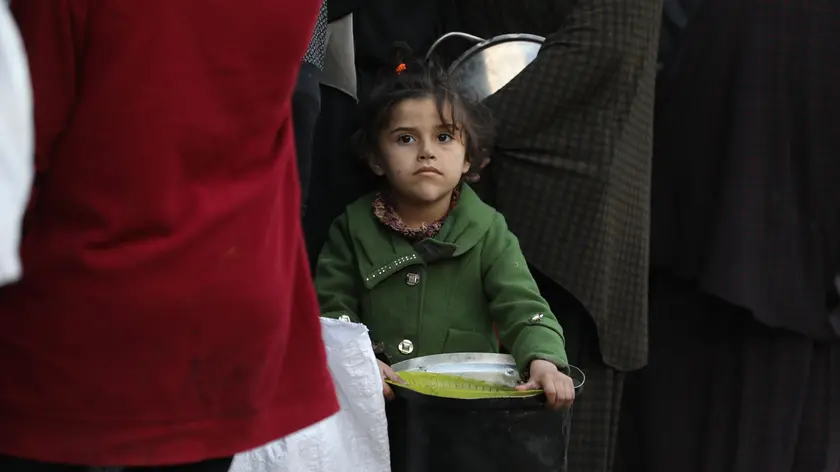 Una bambina in fila per il cibo, in Medio Oriente