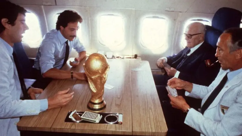 Enzo Bearzot gioca a carte con il presidente della Repubblica, Sandro Pertini, ed i giocatori Dino Zoff e Franco Causio nell'aereo che trasporta gli Azzurri in Italia dopo la vittoria nella finale della Coppa del Mondo, in una immagine del 12 luglio 1982. ANSA