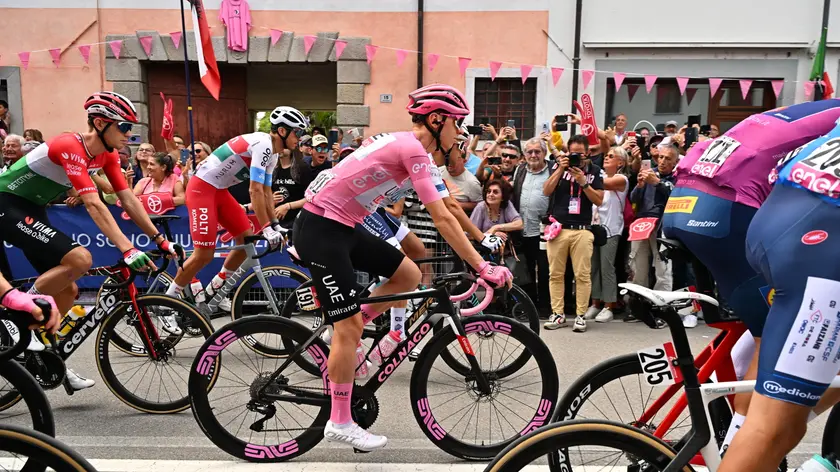 epa11366129 Slovenian rider Tadej Pogacar (C) of Uae Team Emirates wearing the overall leader's pink jersey, prepares for the start of the 19th stage of the 107 Giro d'Italia 2024, cycling race over 157 km from Mortegliano to Sappada, in Mortegliano, Italy, 24 May 2024. EPA/LUCA ZENNARO