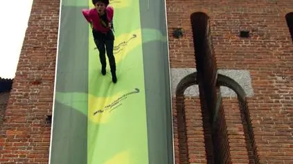Attivista di Greenpeace srotola un tappeto verde con un guanto disegnato blitz sulla torre del Castello Sforzesco di Milano, 20 febbraio 2013. Il blitz vuole lanciare un guanto di sfida al mondo della Moda invitato con l'iniziativa denominata 'Thefashionduel'. ANSA/UFFICIO STAMPA GREENPEACE +++EDITORIAL USE ONLY - NO SALES+++