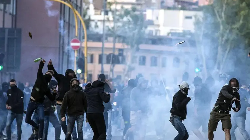 Supporters face policemen outside Olimpico Stadium at the end of Italian Serie A soccer match between As Roma and Ss Lazio, Rome 25 May 2015. Two soccer fans were stabbed near the Olympic stadium before the highly anticipated Roma-Lazio derby, police said Monday. The pair, each stabbed in the abdomen, were rushed by ambulance to hospital as code red emergencies.ANSA/ANGELO CARCONI