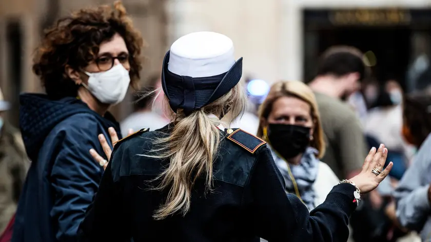 A local police officer checks people and tourists in Fontana di Trevi during the first day of mandatory protective masks outdoors in the Lazio Region for the Coronavirus Covid-19 pandemic emergency in Rome, Italy, 03 October 2020. ANSA/ANGELO CARCONI