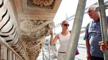 SULL’IMPALCATURA. Dalla sinistra in alto Maria Teresa Bonaldo insieme a don Remigio Brusadin, il vicesindaco Giuseppe Pan, l’arciprete, Gianni Toffanello e 2 delicate fasi di restauro A fianco la croce risistemata sulla sommità della facciata del duomo e a sinistra il Cristo benedicente che invece richiederà parecchi interventi