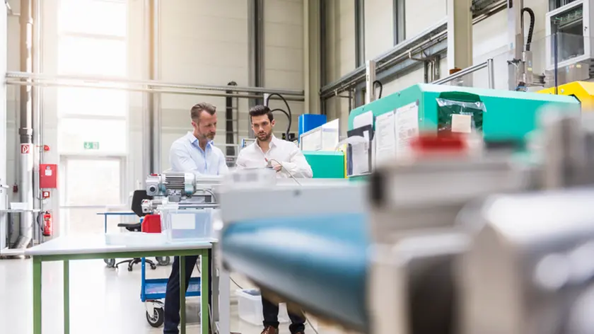 Two men in factory at machine