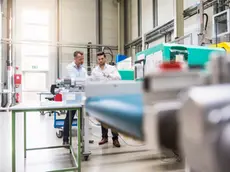 Two men in factory at machine