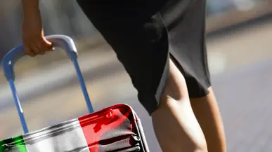 Businesswoman in skirt and high heels walking with luggage, low section, rear view (tilt) --- Image by © Juice Images/Corbis