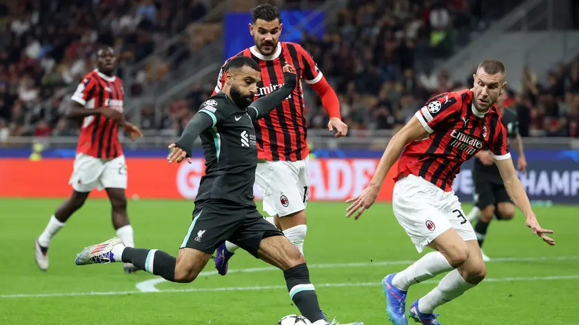 Liverpool's Mohamed Salah (L) challenges for the ball with AC Milan’s Theo Hernandez (C) and his teammate Srahinja Pavlovic during the UEFA Champions League soccer match between Ac Milan and Liverpool at Giuseppe Meazza stadium in Milan, 17 September 2024. ANSA / MATTEO BAZZI