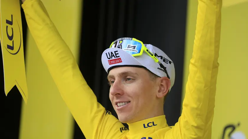 epa11468390 Slovenian rider Tadej Pogacar of UAE Team Emirates celebrates in the overall leader's yellow jersey on the podium after the tenth stage of the 2024 Tour de France cycling race over 187km from Orleans to Saint-Amand-Montrond, France, 09 July 2024. EPA/GUILLAUME HORCAJUELO