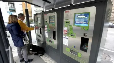 PIAZZA INSURREZIONE. Cittadini intenti a pagare davanti alle nuove colonnine automatiche piazzate nel parcheggio gestito da Aps e preso d’assalto dagli abusivi