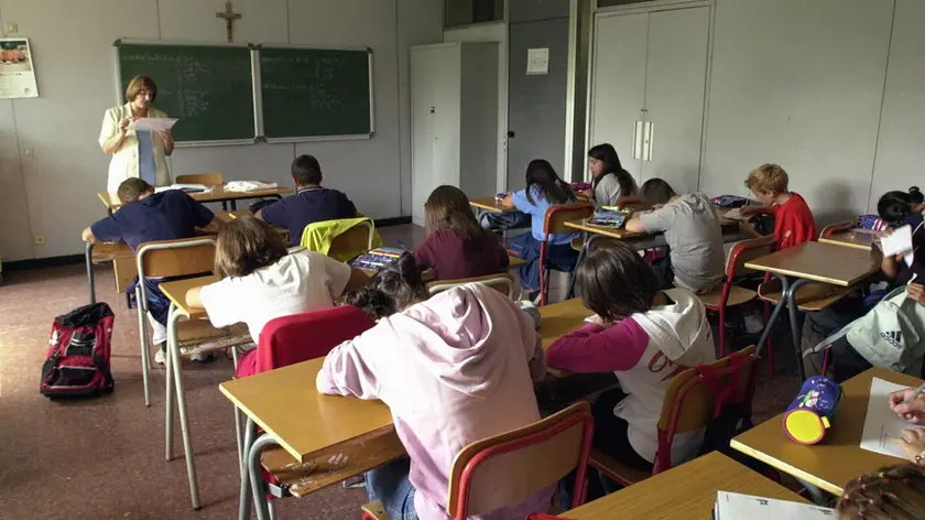 Un’insegnante fa lezione in una classe: prima campanella l'11 settembre