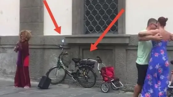 Roberta Righetti mentre suona davanti al Bo' con la gente che balla. Indicata dalle frecce la bicicletta con il carrello rubata