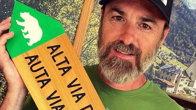 Lo scrittore Matteo Righetto con il cartello dell'Alta via dell'orso 2
