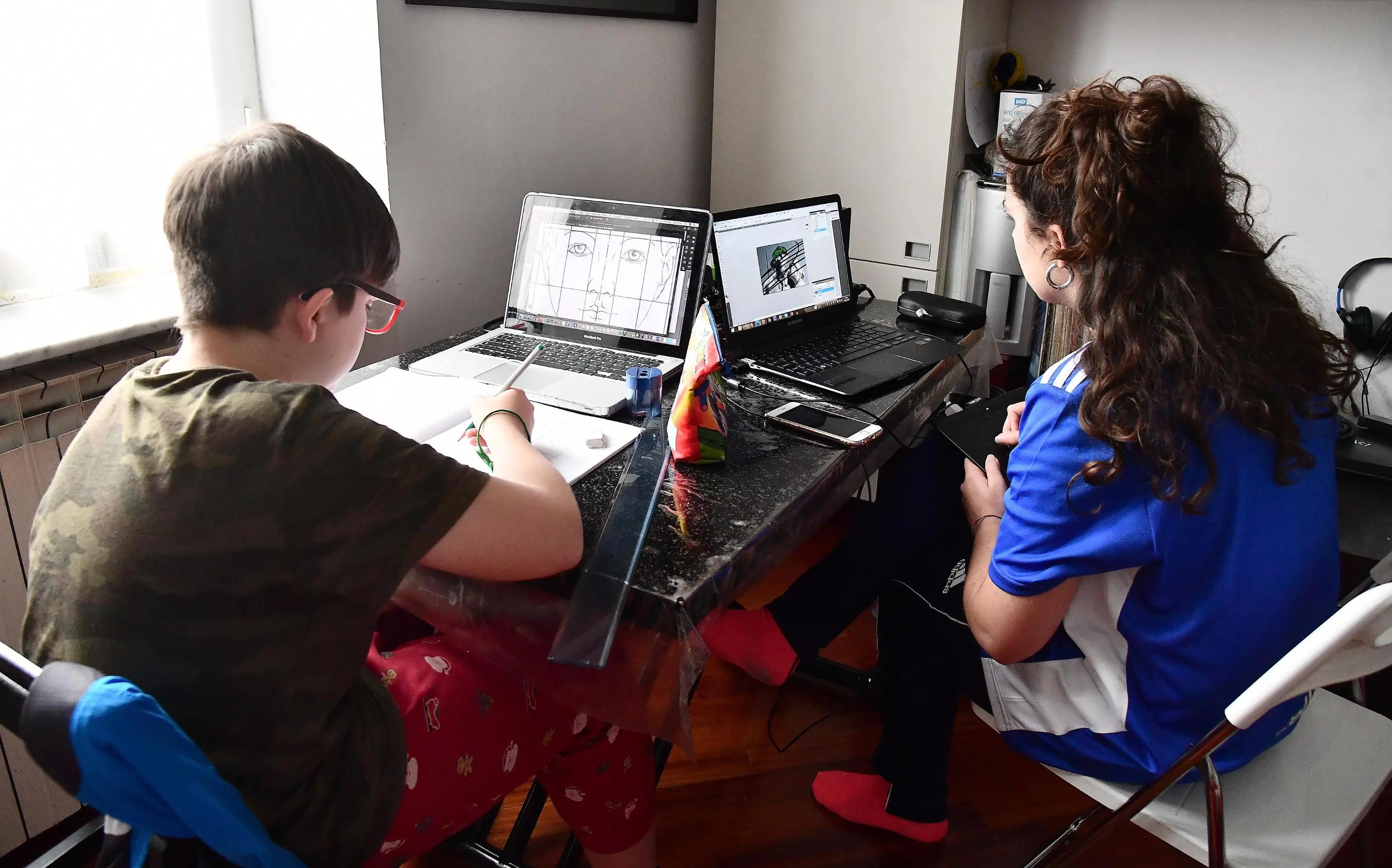 tTo students do their homework with laptops on your home, Italy, Genova 26 March 2020. As a precautious measure against the spreading of the pandemic COVID-19 disease caused by the SARS-CoV-2 coronavirus, schools and universities are closed and teaching has been diverted to cyberspace in Italy. ANSA/LUCA ZENNARO